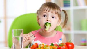 girl eating healthy vegetable