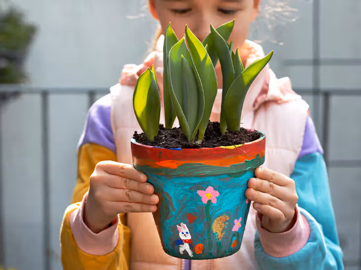 Child holding a self painted terracotta pot filled thumbnail 732x549 1